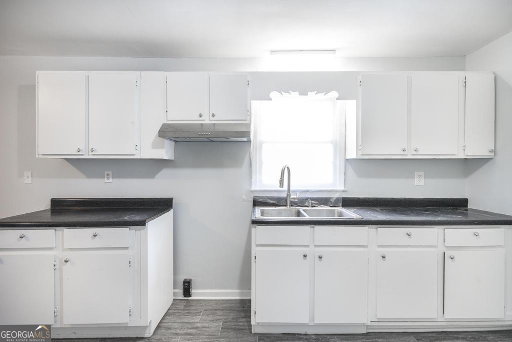 918 Henderson Street Dublin, GA 31021 - Photo 12 of 23 a kitchen with granite countertop white cabinets and a sink