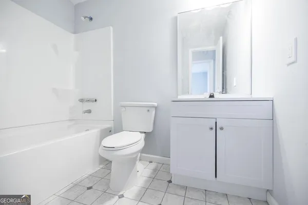 a bathroom with a toilet a sink a mirror and bathtub