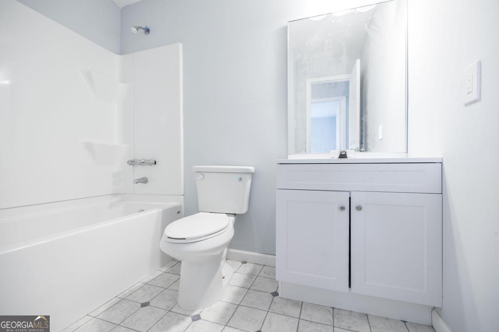 918 Henderson Street Dublin, GA 31021 - Photo 18 of 23 a bathroom with a toilet a sink a mirror and bathtub