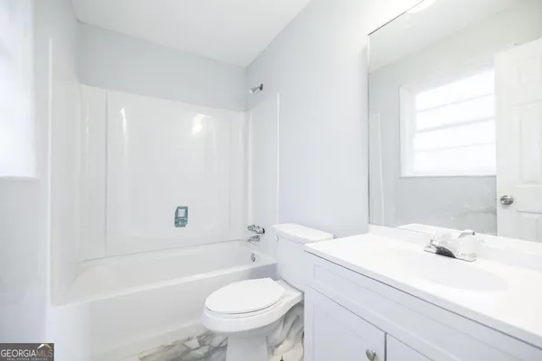 a bathroom with a sink toilet vanity and bathtub
