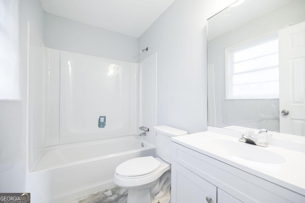 918 Henderson Street Dublin, GA 31021 - Photo 22 of 23 a bathroom with a sink toilet vanity and bathtub