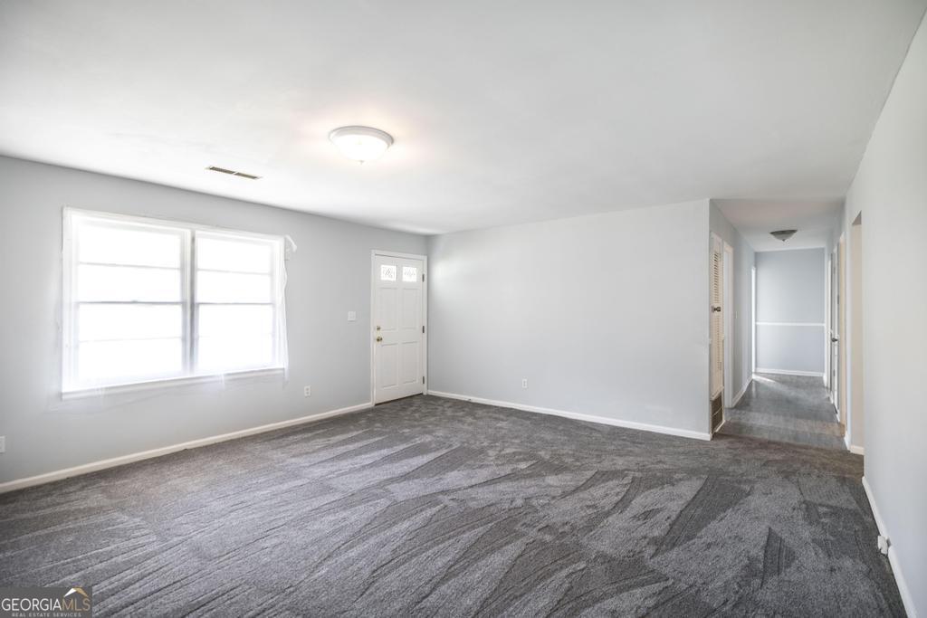 918 Henderson Street Dublin, GA 31021 - Photo 8 of 23 an empty room with wooden floor and windows