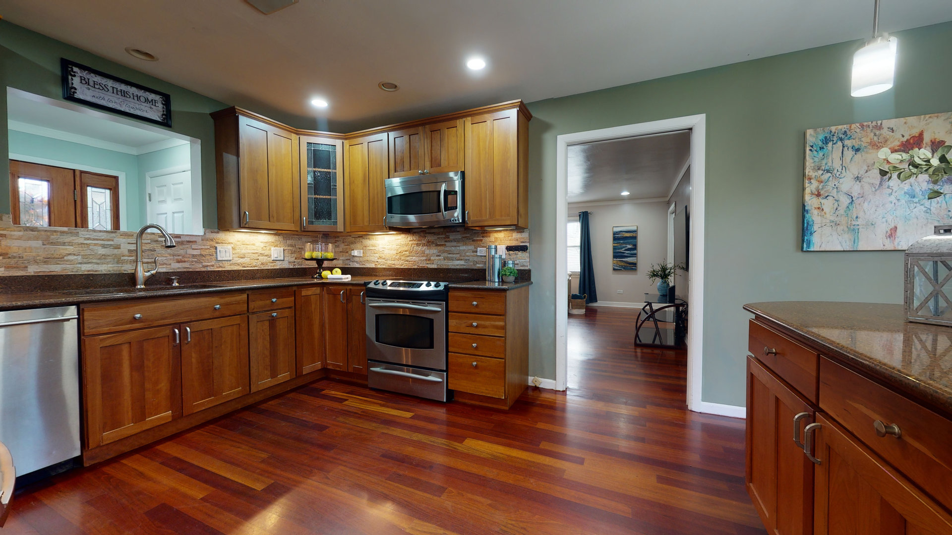 130 Stonegate Road Buffalo Grove, IL 60089 - Photo 2 of 13 a kitchen with stainless steel appliances granite countertop wooden cabinets a sink a stove a dining table and chairs