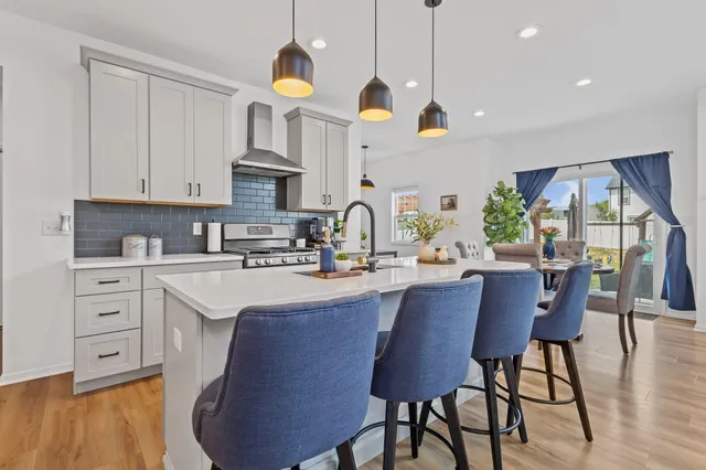 a kitchen with stainless steel appliances granite countertop a sink a stove and cabinets