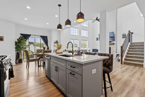 a kitchen with stainless steel appliances granite countertop a sink a stove a refrigerator and island