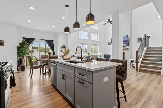 a kitchen with stainless steel appliances granite countertop a sink a stove a refrigerator and island