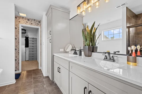 a bathroom with a sink a toilet a mirror and shower