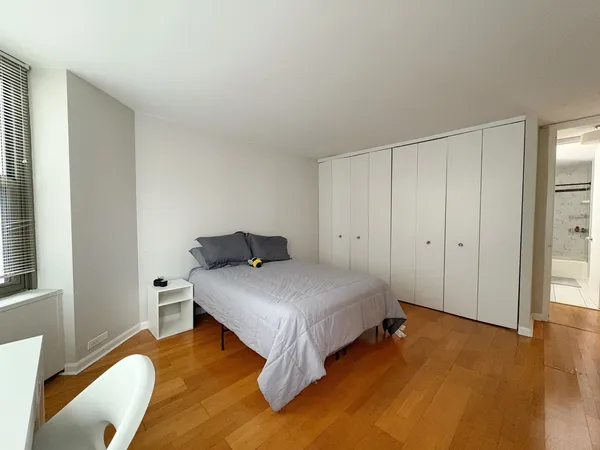 a bedroom with a bed and a large window