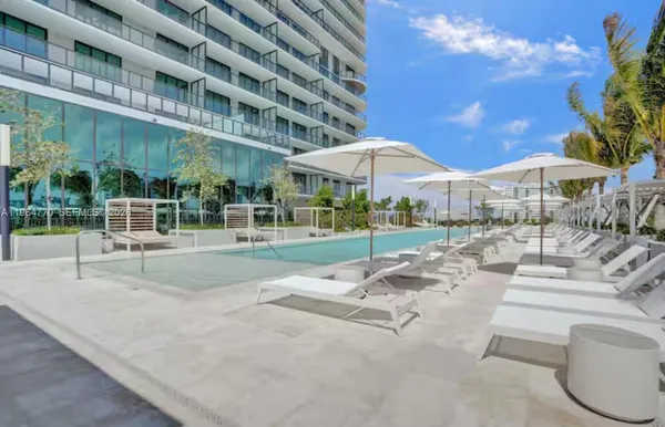a view of a patio with a table and chairs under an umbrella