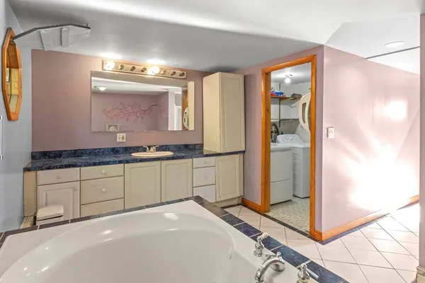 a spacious bathroom with a granite countertop sink and a mirror