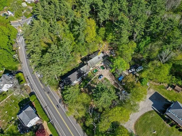 an aerial view of a houses with a lush green hillside