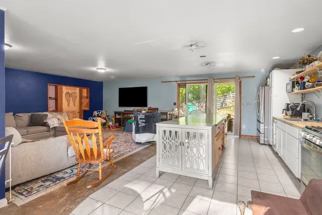 a living room with furniture a flat screen tv and a floor to ceiling window
