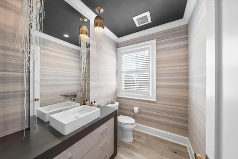 a bathroom with a granite countertop sink a toilet a mirror and shower