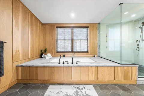 a bathroom with a granite countertop tub and a sink