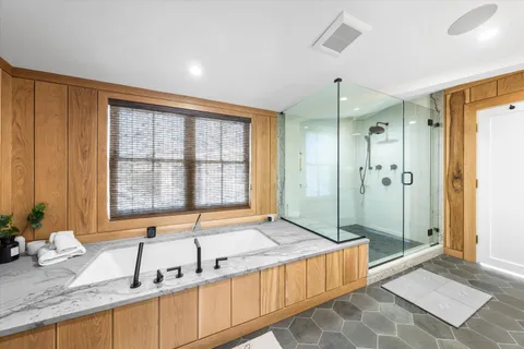 a spacious bathroom with a granite countertop tub sink and mirror