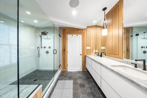 a bathroom with a double vanity sink mirror and shower