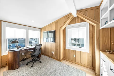 a view of a workspace with furniture and a window