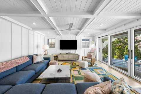 a living room with furniture flat screen tv and a large window