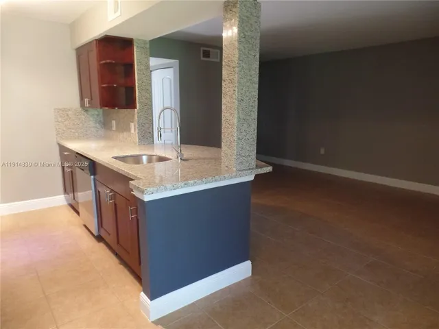 a kitchen with stainless steel appliances granite countertop a sink and a stove