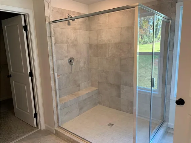 a bathroom with a glass shower and a glass door