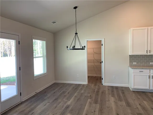 a view of empty room with wooden floor and window