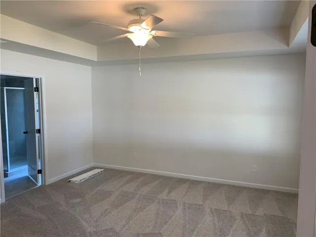 an empty room with a ceiling fan and a window