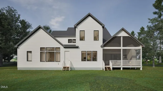 a front view of a white house with a yard and a garden
