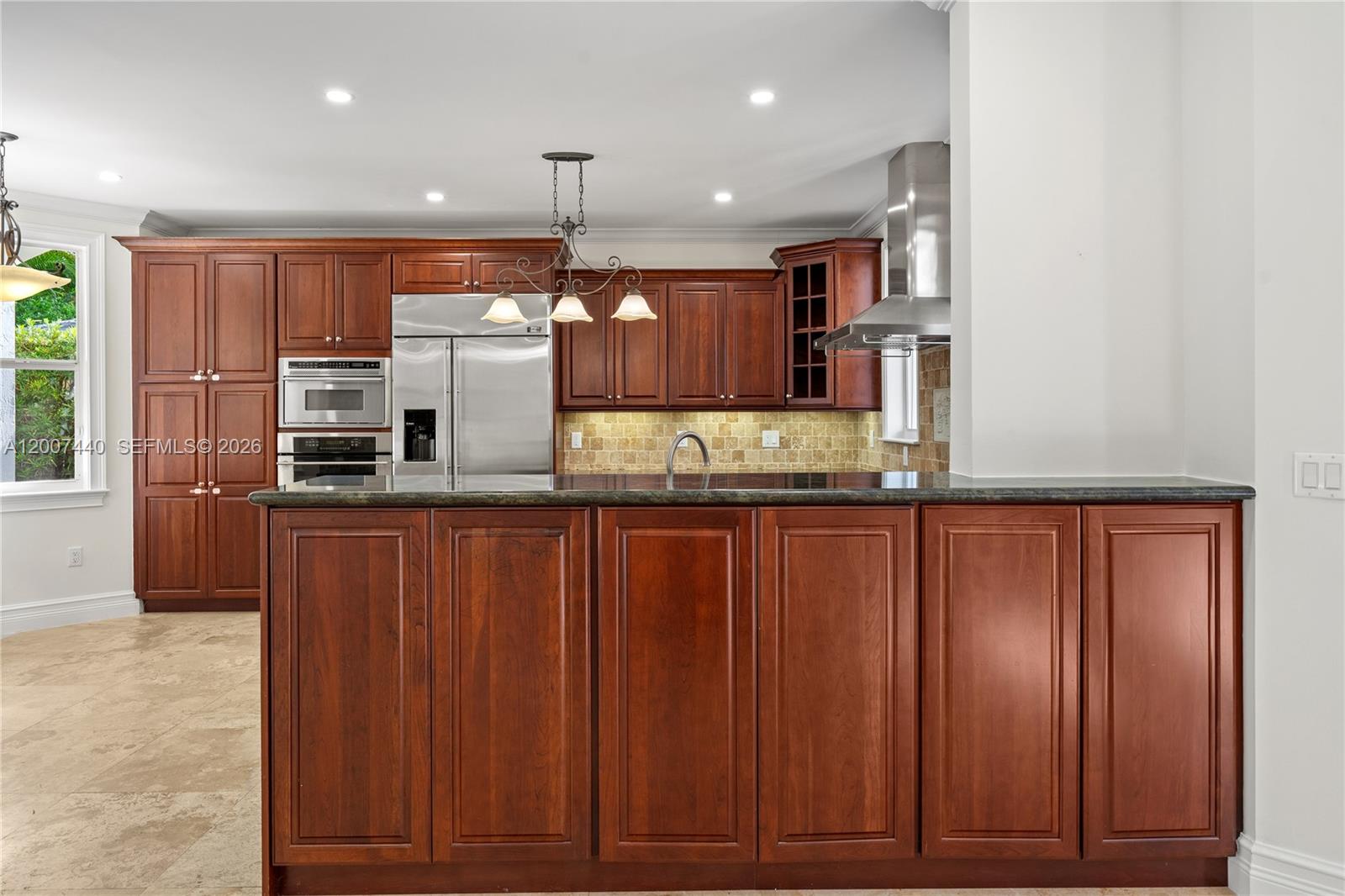 4065 Battersea Road Miami, FL 33133 - Photo 9 of 39 a kitchen with kitchen island granite countertop wooden cabinets and stainless steel appliances