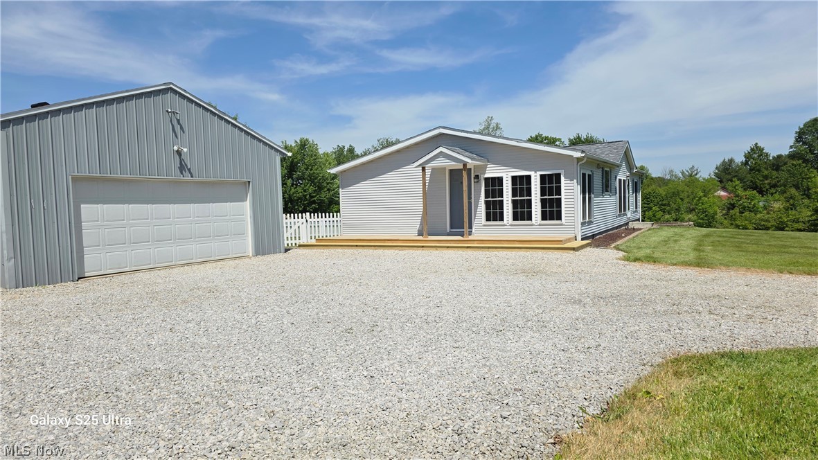 294 Twp 150 Road Sullivan, OH 44880 - Photo 39 of 39 Expansive gravel driveway leading to a modern residence and a large metal-sided outbuilding