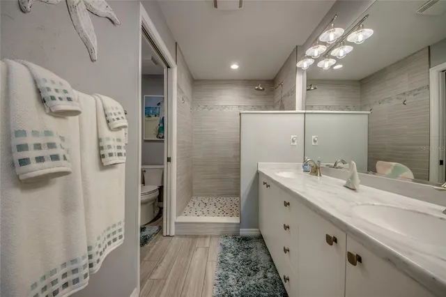 a bathroom with a double vanity sink mirror and shower