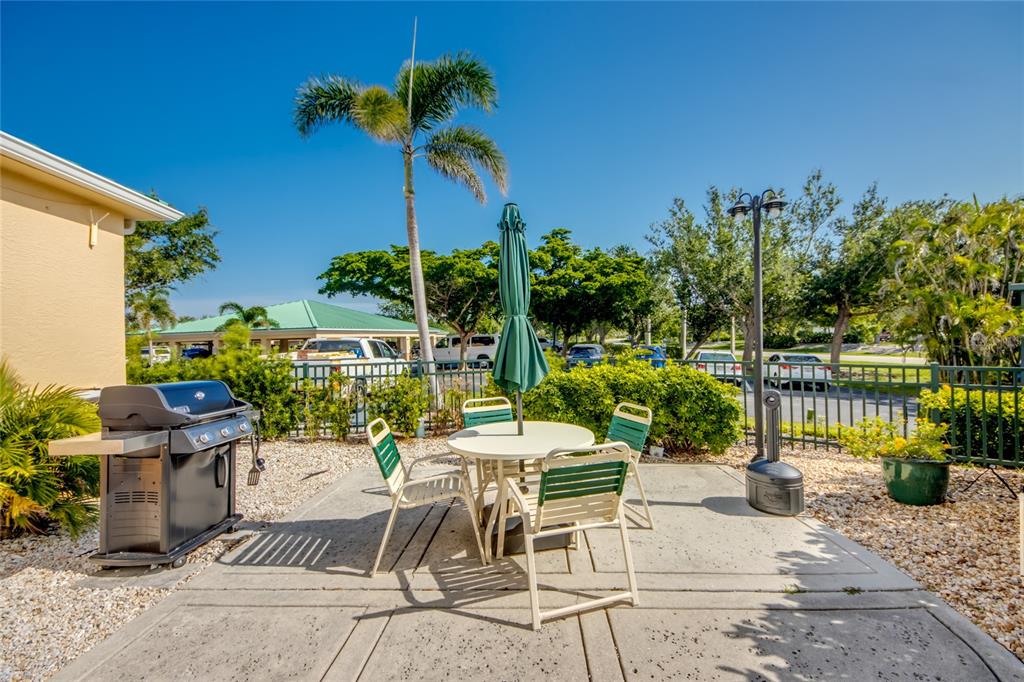 2090 Matecumbe Key Road, Unit 1202 Punta Gorda, FL 33955 - Photo 31 of 42 a view of a patio with a table and chairs potted plants and palm tree