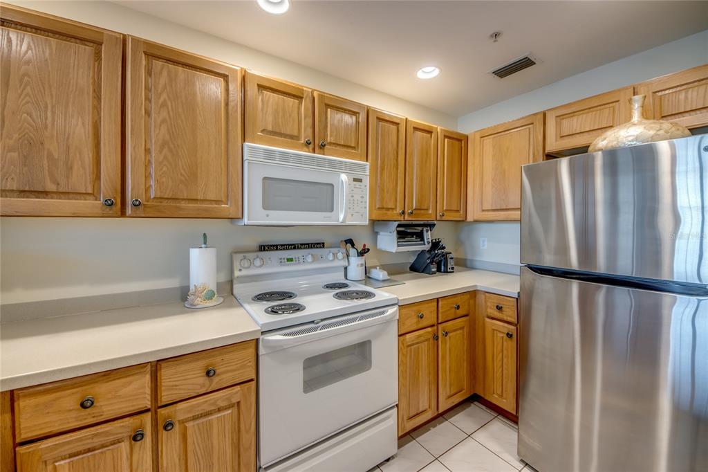 2090 Matecumbe Key Road, Unit 1202 Punta Gorda, FL 33955 - Photo 7 of 42 a kitchen with a refrigerator a stove a sink and cabinets