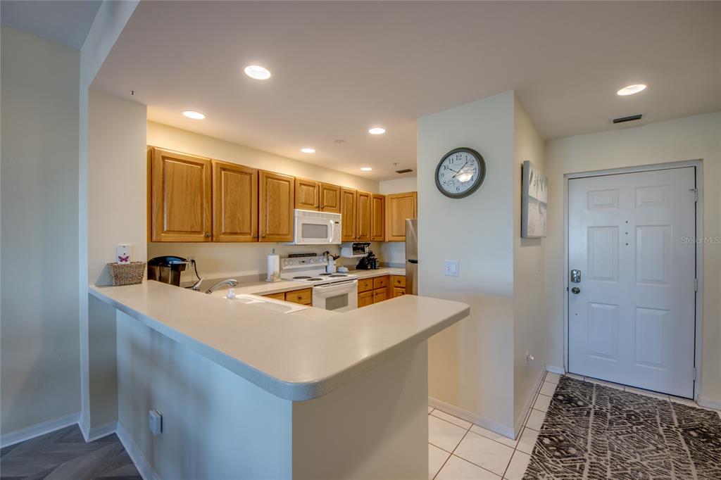 2090 Matecumbe Key Road, Unit 1202 Punta Gorda, FL 33955 - Photo 8 of 42 a view of a kitchen with a sink and dishwasher a refrigerator with wooden floor