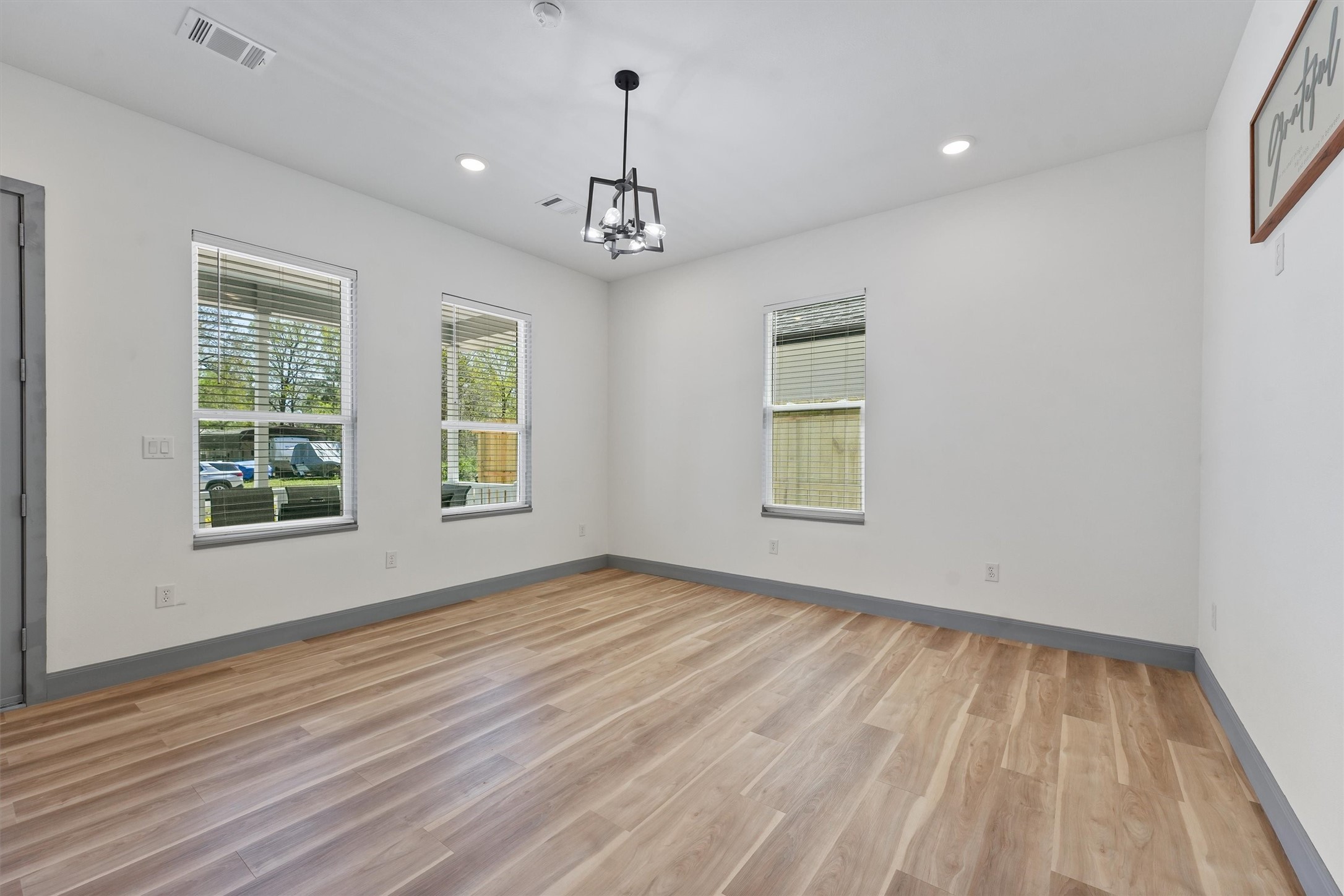 200 Canary Street Point Blank, TX 77364 - Photo 12 of 25 an empty room with wooden floor chandelier and windows