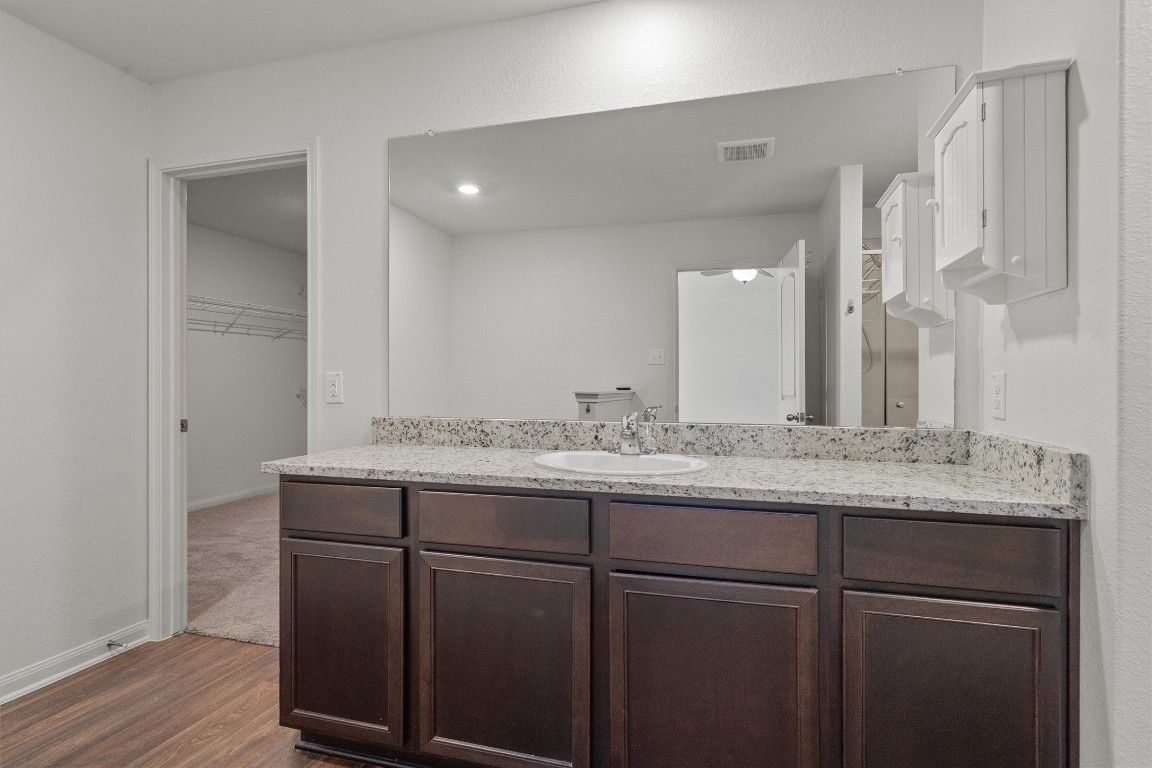 14405 Boomtown Way Elgin, TX 78621 - Photo 15 of 39 a bathroom with a granite countertop sink and a mirror