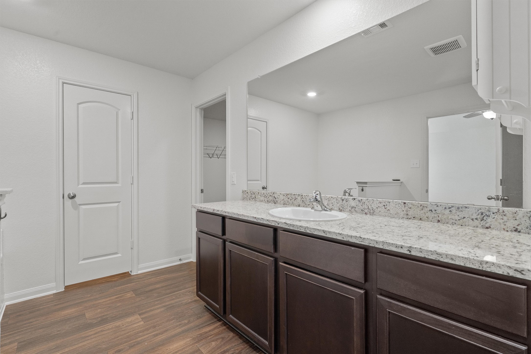 14405 Boomtown Way Elgin, TX 78621 - Photo 16 of 39 a bathroom with a granite countertop sink and white cabinets