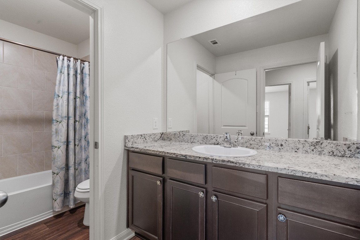 14405 Boomtown Way Elgin, TX 78621 - Photo 27 of 39 a bathroom with a granite countertop sink and a mirror