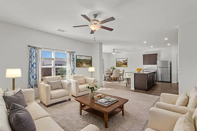 a living room with furniture a table and a large window
