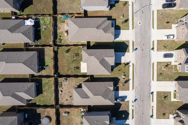 an aerial view of residential building with parking and yard