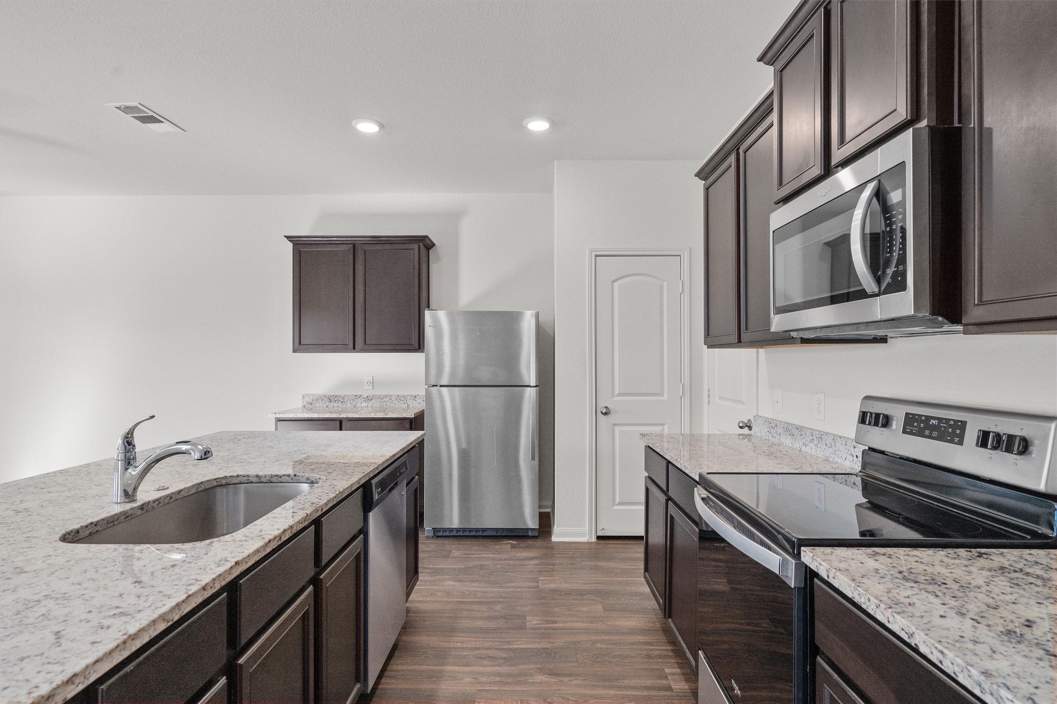 14405 Boomtown Way Elgin, TX 78621 - Photo 5 of 39 a kitchen with stainless steel appliances granite countertop a sink stove and refrigerator