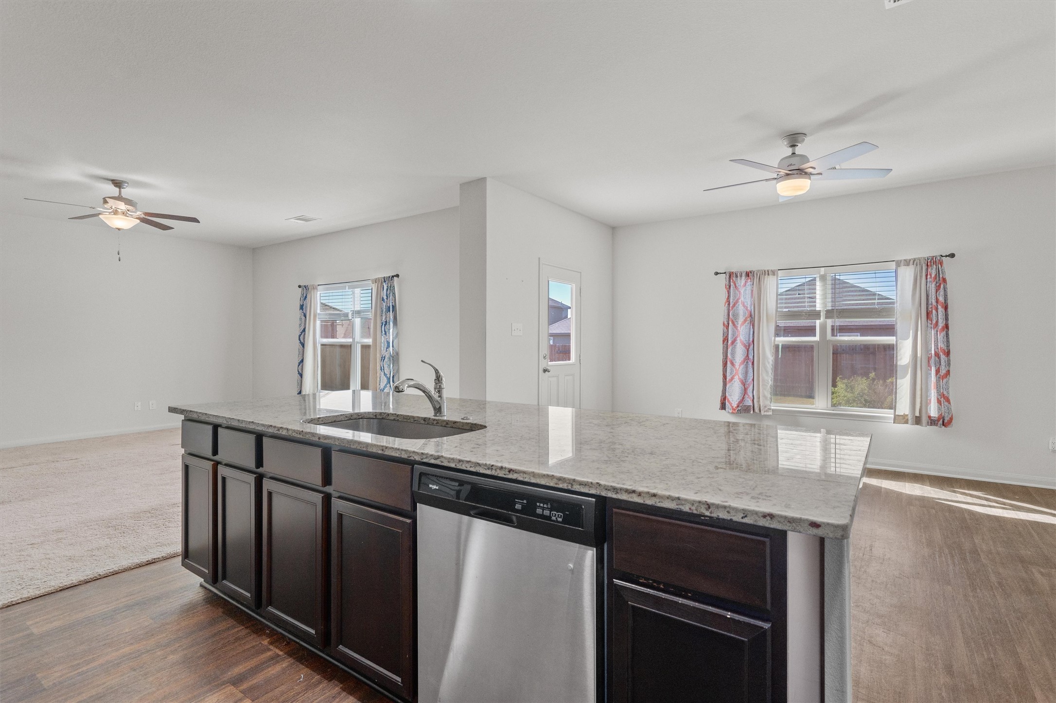 14405 Boomtown Way Elgin, TX 78621 - Photo 36 of 39 a kitchen with granite countertop a sink cabinets and wooden floor