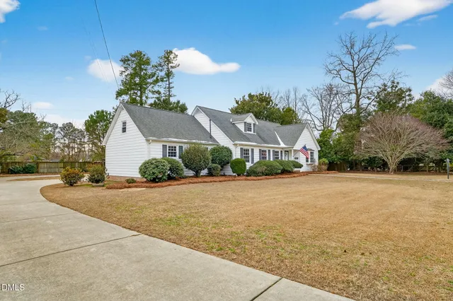 a front view of a house with a yard and trees