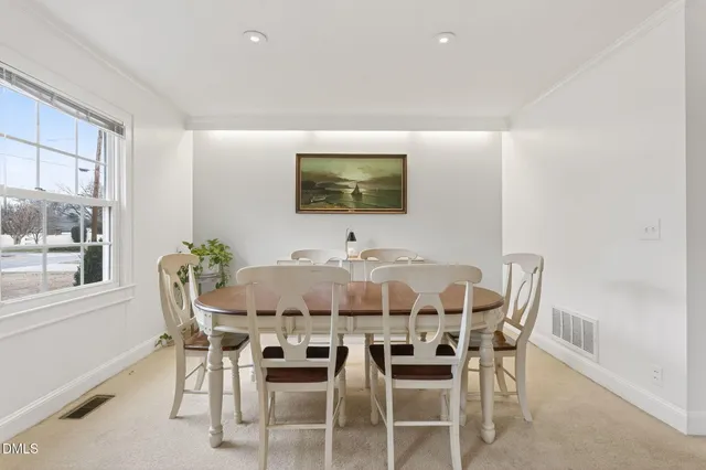 a kitchen with granite countertop a refrigerator a sink dishwasher a stove and white countertops with wooden floor