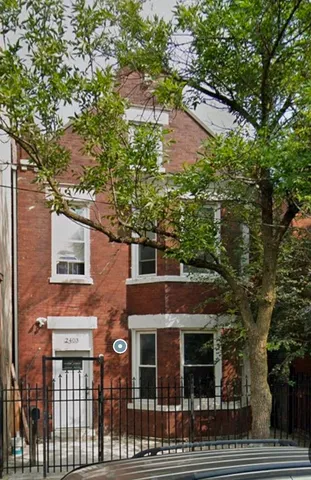 a front view of a house with a tree