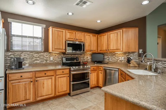 a kitchen with sink a microwave and cabinets