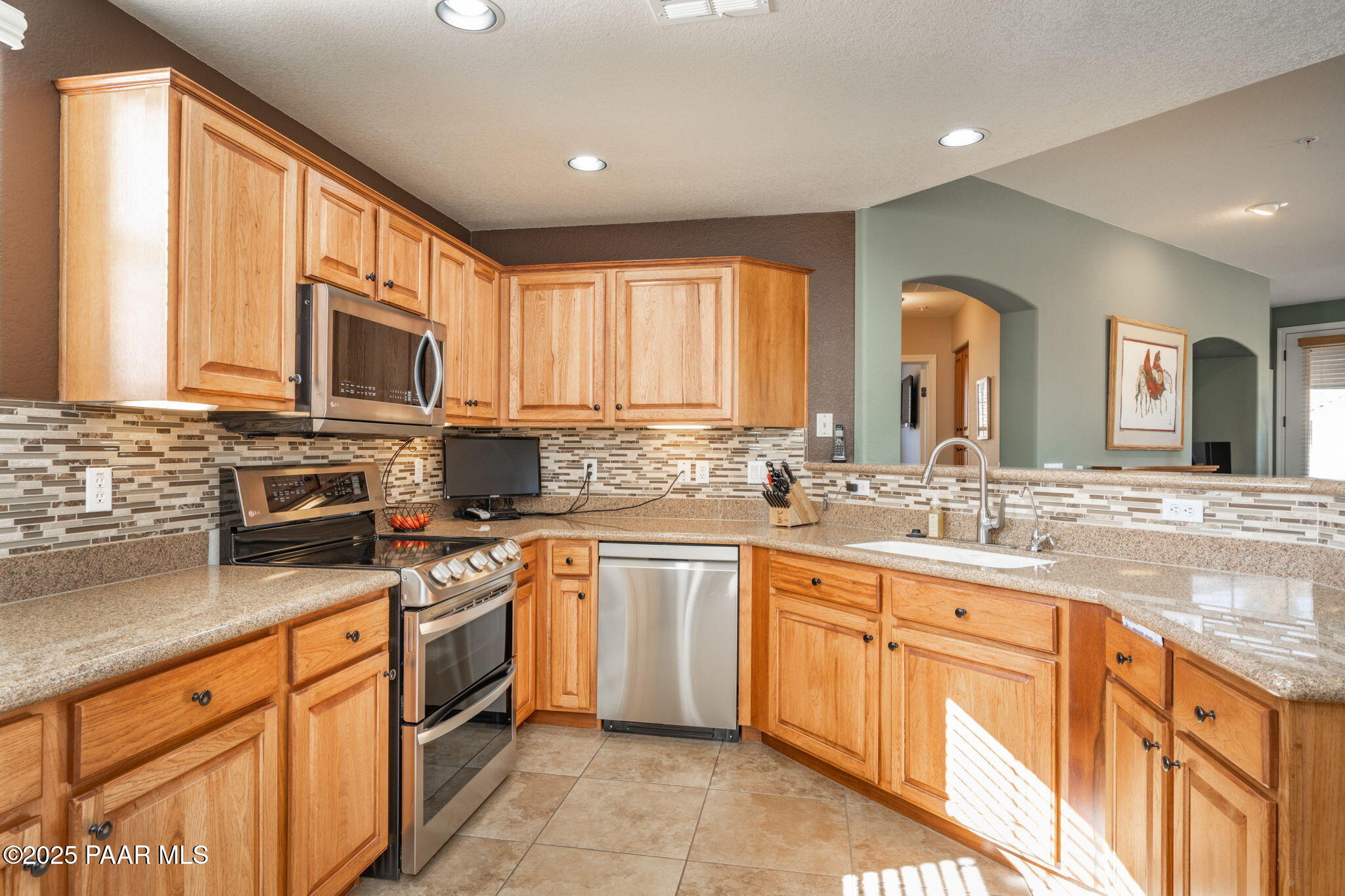 1716 Alpine Meadows Lane, Unit 305 Prescott, AZ 86303 - Photo 12 of 49 a kitchen with stainless steel appliances granite countertop a stove a sink and a microwave