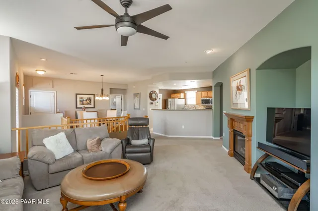 a living room with furniture a flat screen tv and kitchen view