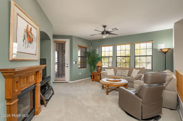 a living room with fireplace furniture and a large window