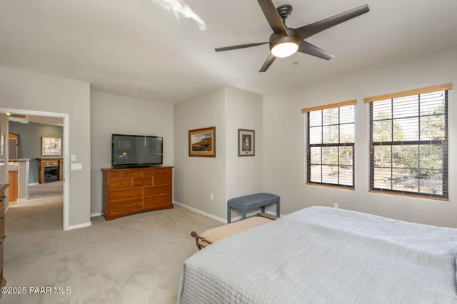 a bedroom with a large bed a flat screen tv and a window