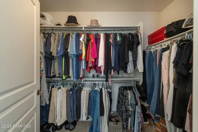 a view of walk in closet with clothes and shoes